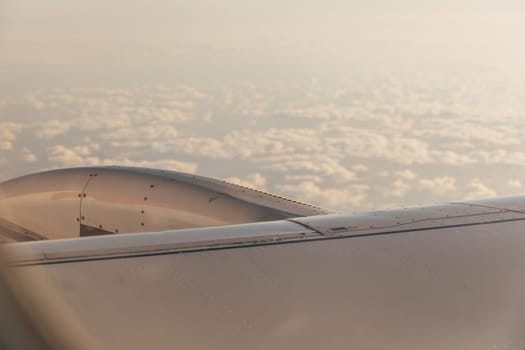 A wing of a passenger plane and clouds