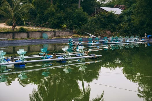 Aerator blades in a pond on a fish farm. Breeding fish and shrimps in an artificial pond