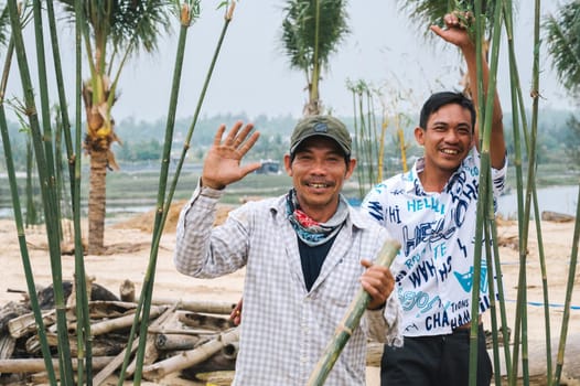 Two happy Asian Vietnamese male builders construction workers smile in nature. Tam Tien, Quang Nam province, Vietnam - April 10, 2025