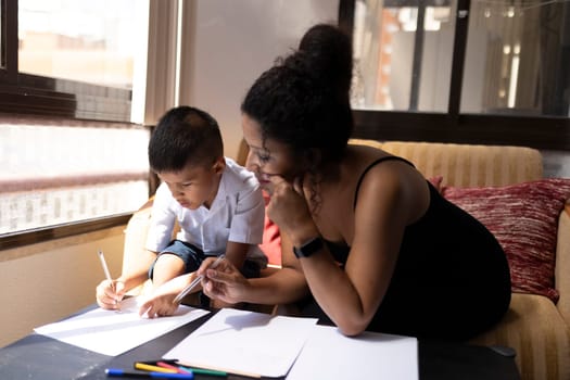 Mother assisting her son with homework, fostering a positive learning environment at home