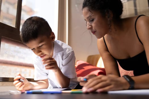 Mother assisting her son with schoolwork, fostering a positive learning environment at home