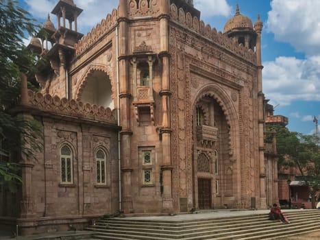 A wide exterior shot of a grand, historic stone building showcasing elaborate architectural details, including multiple domes, arches, and finely carved facades. This image is ideal for themes related to heritage, historical sites, cultural tourism, and detailed architectural design.Majestic Historic Building with Intricate Stone Architecture, Chennai, Tamil Nadu. High quality photo