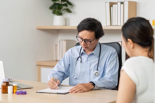 A doctor writes notes while consulting a patient in a modern medical office, focusing on health and wellness.