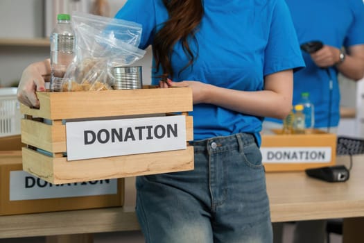 A volunteer presenting a donation box, emphasizing the importance of community support and generosity.