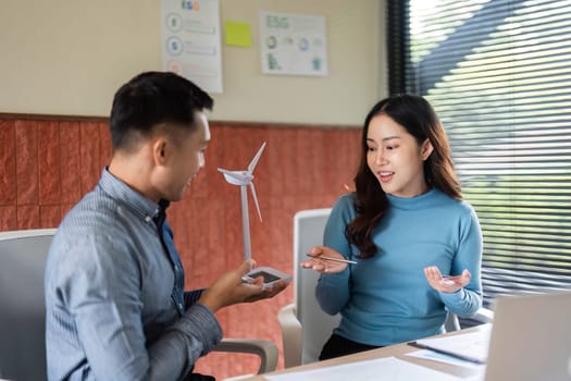 A man and woman engaged in a conversation about ESG initiatives, showcasing teamwork and innovative thinking.