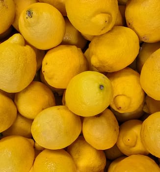 Bright yellow lemons grouped together, presenting an inviting and fresh appearance suitable for culinary or beverage uses, evoking sunny and refreshing vibes. Lemon stack. A vibrant image of fresh, ripe lemons top view. Rich vitamin c, natural and fresh lemon stack