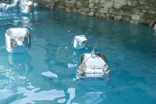 Silver balloons float in pools for a birthday party decorations