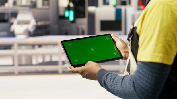 Photovoltaics plant worker uses chroma key notebook to follow maintenance procedures. Solar panels factory engineer analyzes performance data with isolated screen laptop, camera B close up