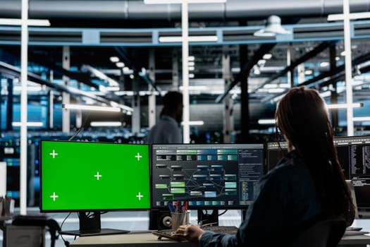 Developer in data center at green screen PC uses AI for machine learning workloads. IT specialist in server hub uses artificial intelligence on chroma key computer to perform demanding computing tasks