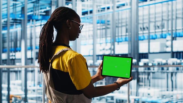 Smart factory specialist using mockup laptop to test automated systems and ensure reliability. Woman uses isolated screen notebook to identify bottlenecks and optimize equipment, camera A