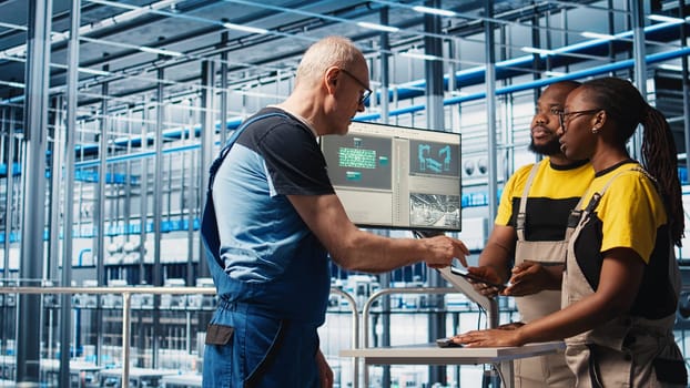 Experienced team leader doing induction to new trainees in industry 4.0 photovoltaics plant. Senior engineer in smart solar panels factory teaching interns to maximize power generation, camera A