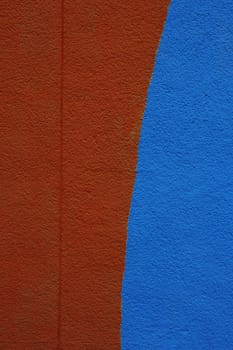 Freshly painted wall, half blue and half brown.
