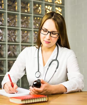 female doctor writing a prescription. young doctor writes a prescription drug in Notepad
