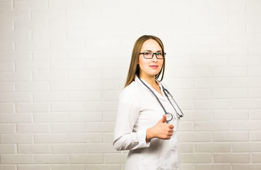 Portrait of woman doctor showing thumbs up gesture.