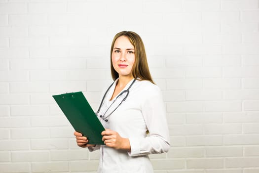 Smiling medical doctor woman with stethoscope on white background.