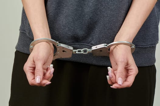 women's hands are handcuffed in close-up. High quality photo