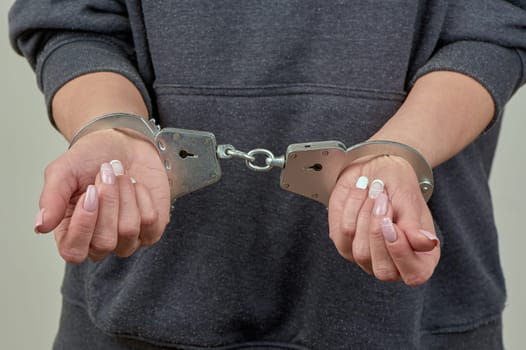 women's hands are handcuffed in close-up. High quality photo