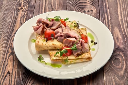 juicy pancakes with bacon and tomatoes on a white plate. High quality photo