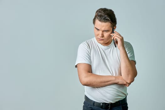 a man on a gray background is talking on the phone. High quality photo