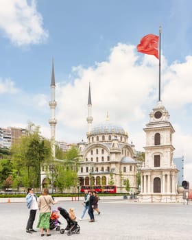 Istanbul, Turkey - May 5 2023: Nusretiye Clock Tower, or Tophane Clock Tower, and Nusretiye imperial Ottoman Mosque, with few pedestrians, Galata Port, Tophane neighborhood, Beyoglu district