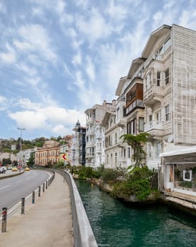 Wooden traditional residential buildings by a narrow water canal near Bosphorus strait, in Arnavutkoy neighborhood, Besiktas district, Istanbul, Turkiye, in a sunny spring day