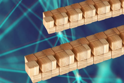 Towers from wooden blocks over abstract blurred blue technology or business  background with bright rays. Copy space. Wood blocks game.