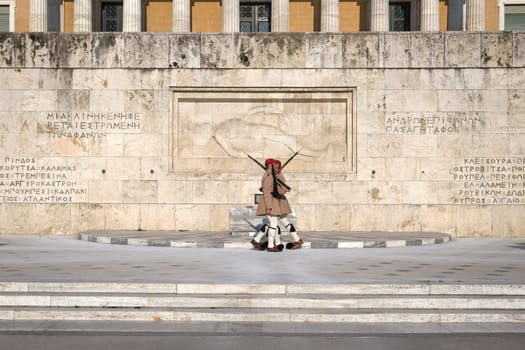 Ceremony of Presidential guard Evzones by the Greek tomb of Unknown Soldier. Evzones in summer uniform, cross by. Wide shot.