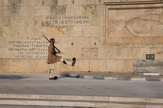 Ceremony of Presidential guard Evzones by the Greek tomb of Unknown Soldier. Evzone in summer uniform marches, leg up. Close shot.