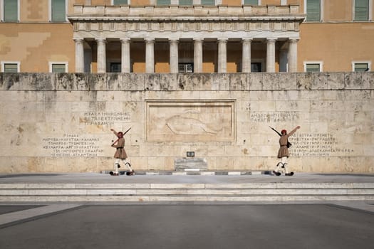 Ceremony of Presidential guard Evzones by the Greek tomb of Unknown Soldier. Evzones in summer uniform separate, hands up. Wide shot.