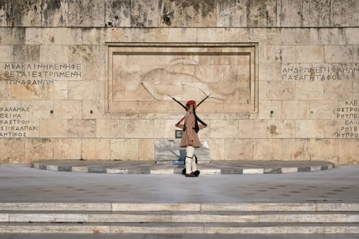 Ceremony of Presidential guard Evzones by the Greek tomb of Unknown Soldier. Evzones in summer uniform stand as one, still. Wide shot.