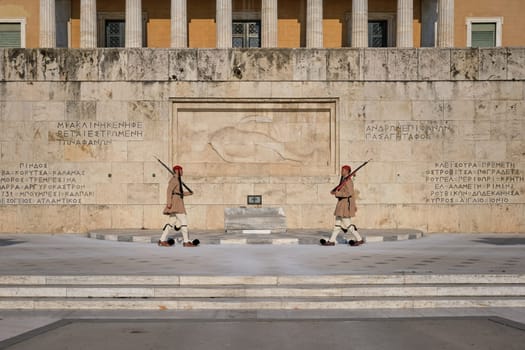 Ceremony of Presidential guard Evzones by the Greek tomb of Unknown Soldier. Evzones in summer uniform walk to each other. Wide shot.