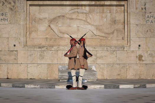 Ceremony of Presidential guard Evzones by the Greek tomb of Unknown Soldier. Evzones in summer uniform stand still and back to back. Close shot.