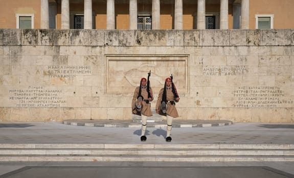 Evzone stand in front of Tomb of Unknown Soldier, legs high up. Wide shot.