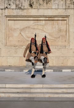 Evzone stand in front of Tomb of Unknown Soldier, legs high up. Close shot.