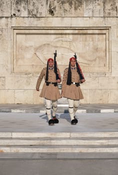 Evzones walk in front of Tomb of Unknown Soldier. Close shot.