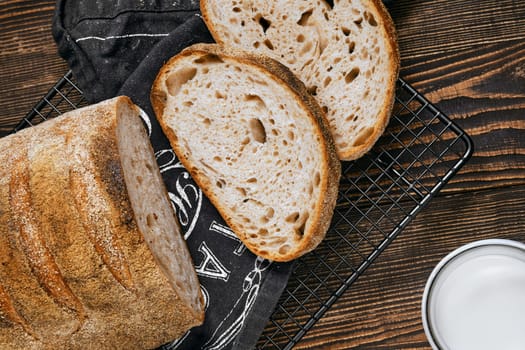 Closeup view of loaf of artisan sourdough bread with porous texture on wooden table