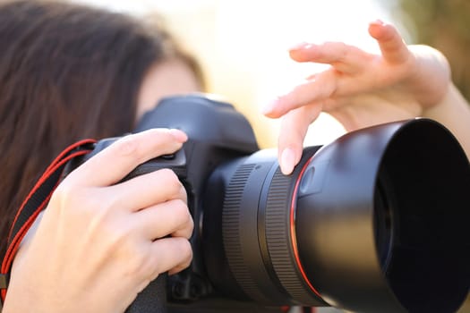 Close up portrait of a photographer hand adjusting focus manually taking photos outdoor