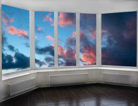 Plastic windows overlooking beautiful dark sunset. View from home window at sunset. Golden sunset outside window. Evening outside window. Modern window on veranda with panorama