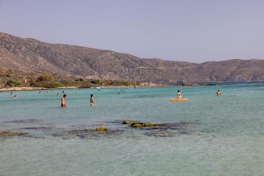 Elafonisi, Crete, Greece - Sept 19, 2021: People relaxing on the famous pink coral beach of Elafonisi on Crete, Mediterannean sea, Greece