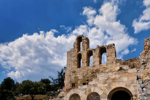 Diagonal dynamic composition of Odeon of Herodes Atticus theater arches on Acropolis hill, Athens, Greece, against bright blue sky and super clouds. Ancient ruins still used as venue for concerts, performances and festivals. UNESCO world heritage.