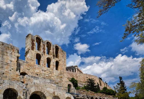 Diagonal dynamic composition of Odeon of Herodes Atticus theater arches on Acropolis hill, Athens, Greece, against bright blue sky and super clouds. Ancient ruins still used as venue for concerts, performances and festivals. UNESCO world heritage.