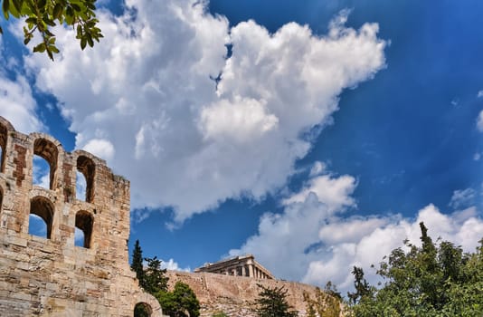 Diagonal dynamic composition of Odeon of Herodes Atticus theater arches on Acropolis hill, Athens, Greece, against bright blue sky and super clouds. Ancient ruins still used as venue for concerts, performances and festivals. UNESCO world heritage.