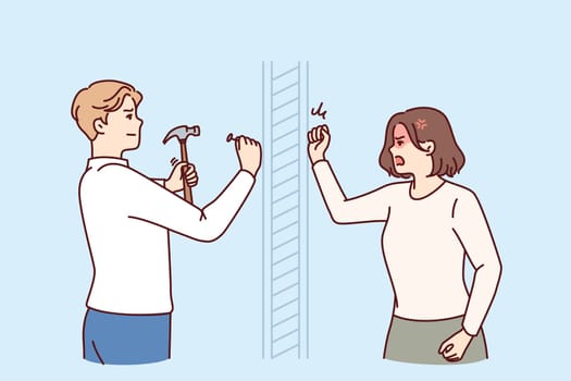 Angry woman knocks on wall swearing at neighbor is doing repairs in apartment and using hammer. Nervous girl quarreling with neighbor hammering nails because of noise caused by renovation