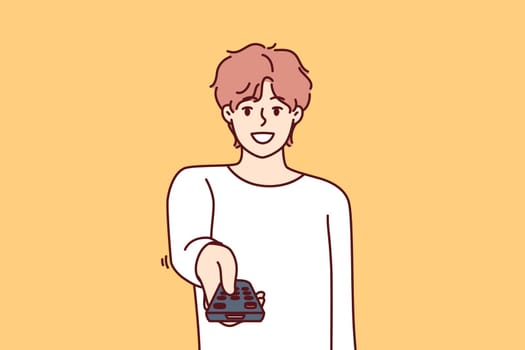 Man holds television remote control switches cable TV channels and smile, choosing interesting show for evening viewing. Happy guy pointing remote at screen wanting to turn off TV box