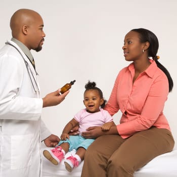 African-American mother and baby girl talking to male pediatrician.