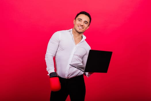Guy in boxing gloves and formalwear punch computer isolated on a red, cyber bullying.