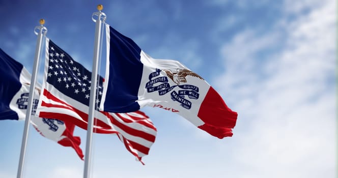 Flags of Iowa and the United States waving in the wind on a clear day. State in the upper Midwestern region of the United States. 3d illustration render. Fluttering fabric.