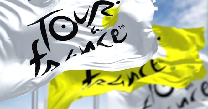 Paris, FR, June 26 2023: Tour de France flags waving. Most important international cycling event of the year. Illustrative editorial 3d illustration render