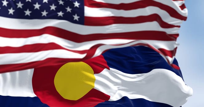 Colorado state flag waving with the national flag of the United States of America on a clear day. 3D illustration render. Fluttering fabric. Selective focus