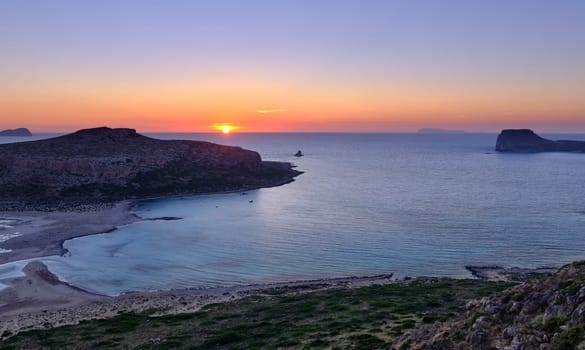 Beautiful sunset view of Cape Tigani and Gramvousa islet from Balos beach, Crete, Greece. Sundown and rich colors of rocky slopes and greenery.